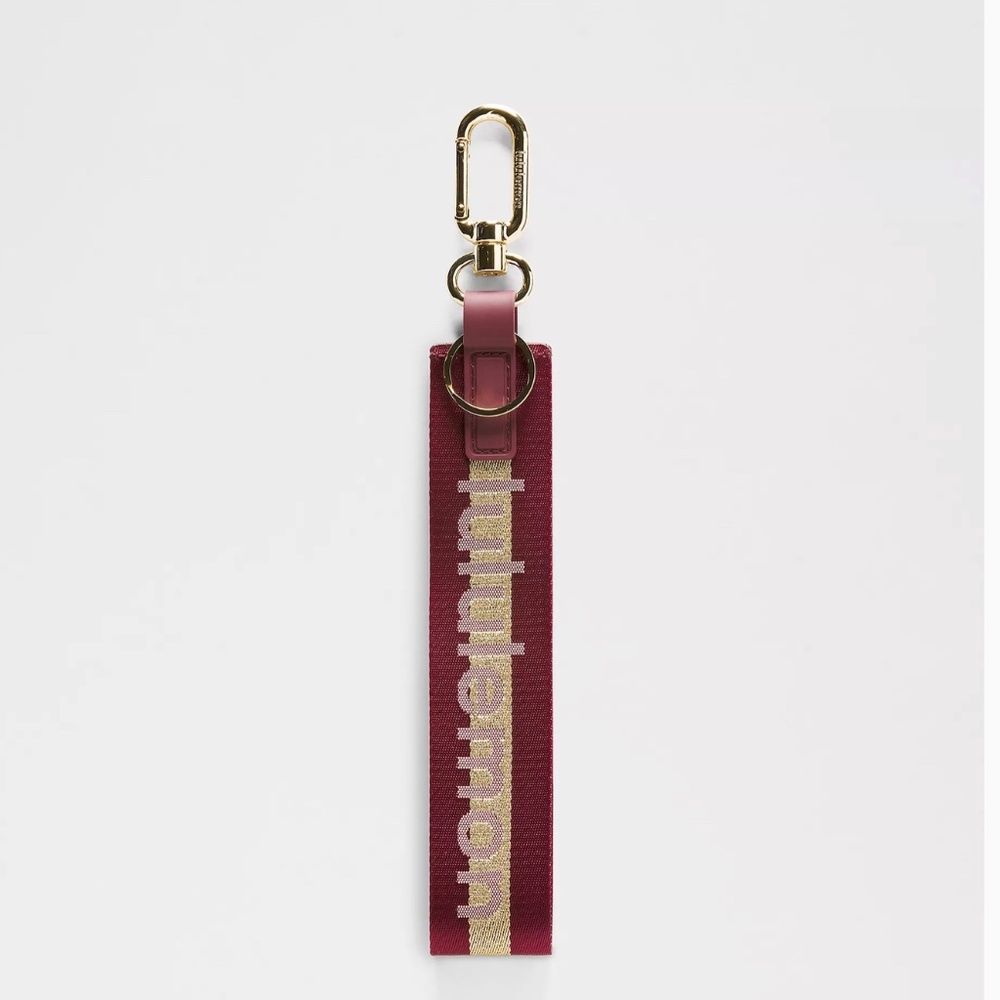 NWT  Lululemon Never Lost Keychain Wordmark in Deep Luxe/Gold/Bone